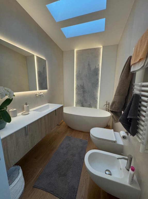 Bagno rifatto con vasca freestanding e lucernari dopo l'intervento edile